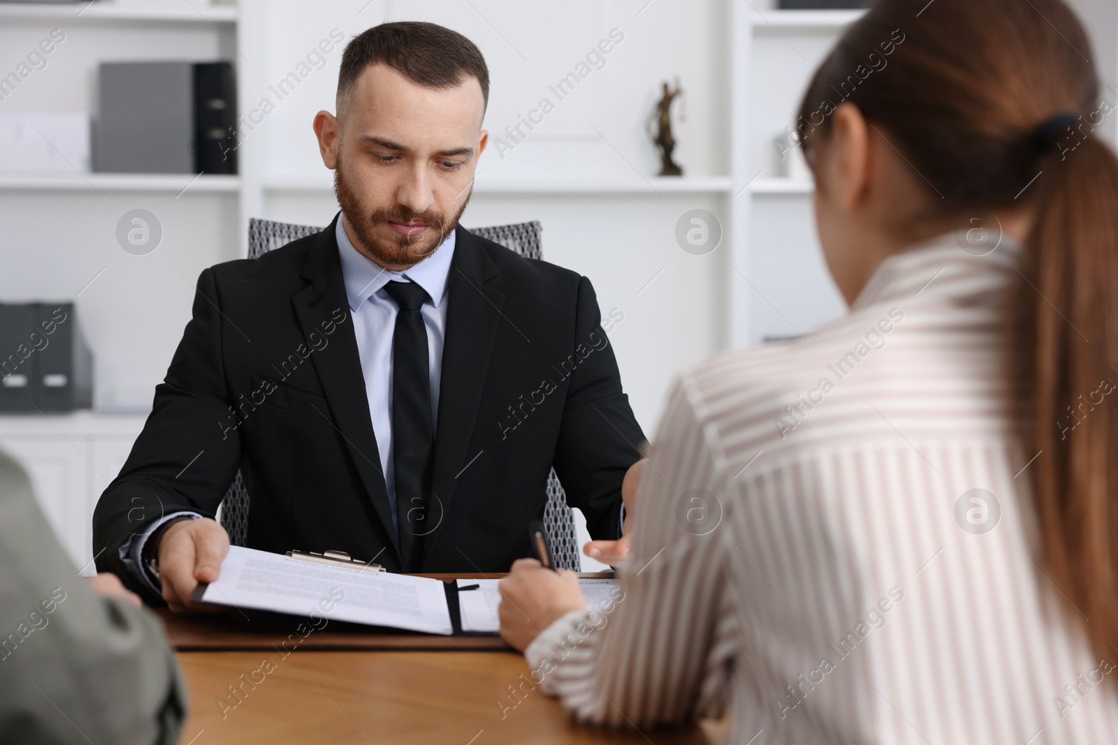 Photo of Man and woman having meeting with professional lawyer at wooden desk indoors