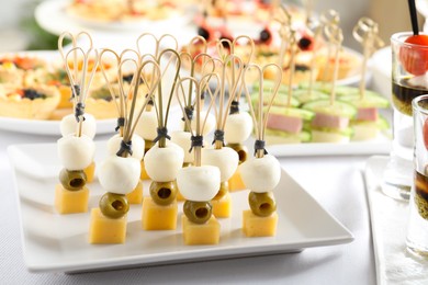 Photo of Many different tasty canapes on white table, closeup