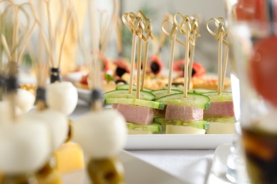 Photo of Many different tasty canapes on white table, closeup