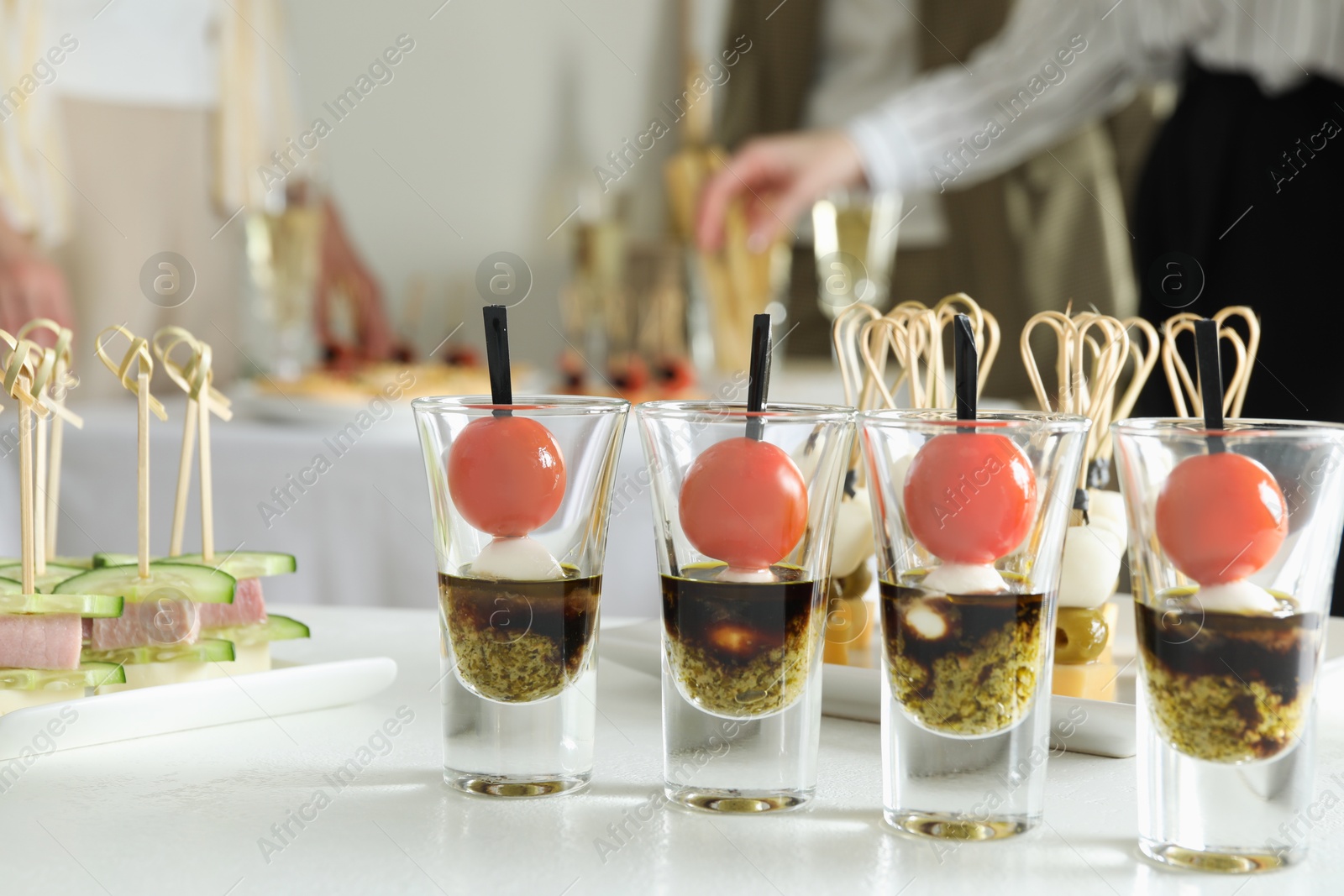 Photo of Many different tasty canapes on white table. People enjoying buffet meals indoors, closeup