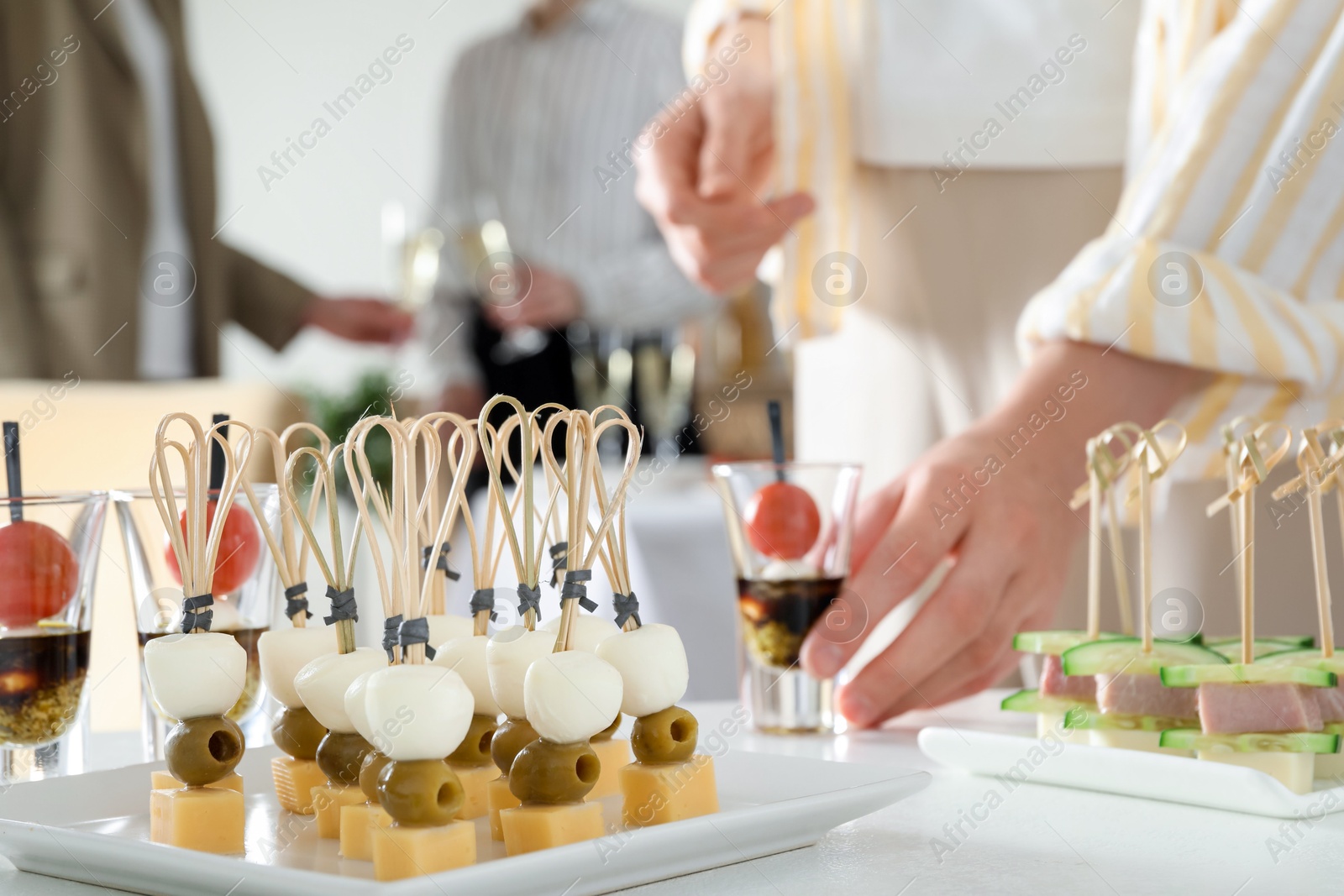 Photo of Many different tasty canapes on white table. People enjoying buffet meals indoors, closeup