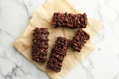 Photo of Delicious chocolate puffed rice bars on white marble table, top view