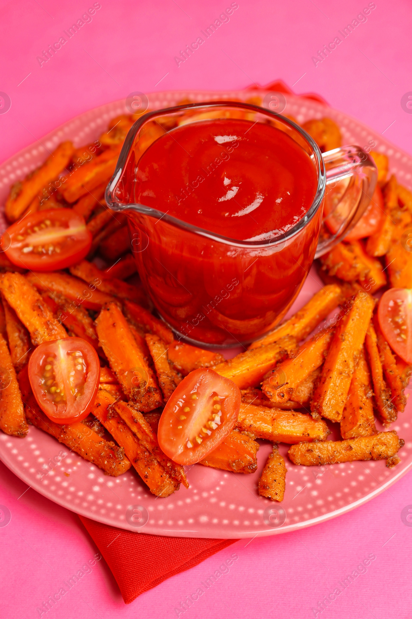 Photo of Tasty ketchup, tomatoes and fried carrots on pink background, closeup