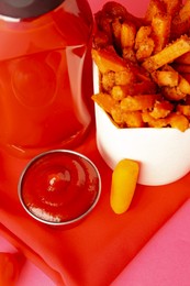 Photo of Tasty ketchup and fried carrots on pink background, closeup