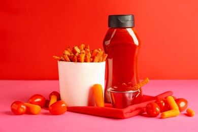 Photo of Tasty ketchup, tomatoes and fried carrots on color background