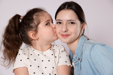 Photo of Cute little girl kissing her sister on white background