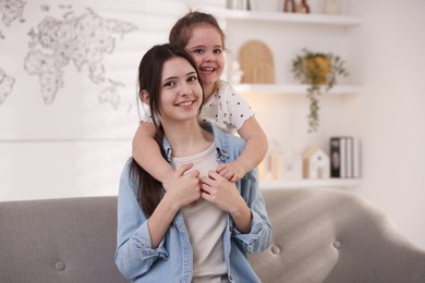 Photo of Portrait of cute little girl and her sister indoors