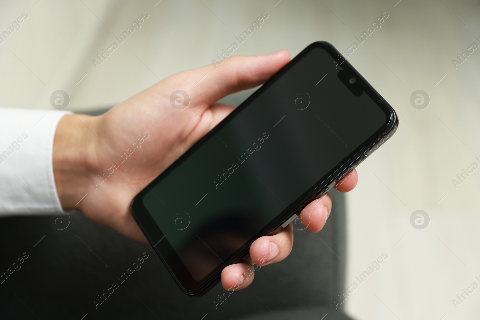 Photo of Man using smartphone with blank screen indoors, closeup