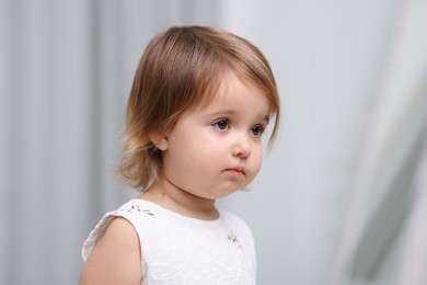 Photo of Cute little baby girl on light grey background