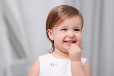 Photo of Cute little baby girl on light grey background