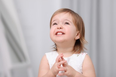 Photo of Cute little baby girl on light grey background