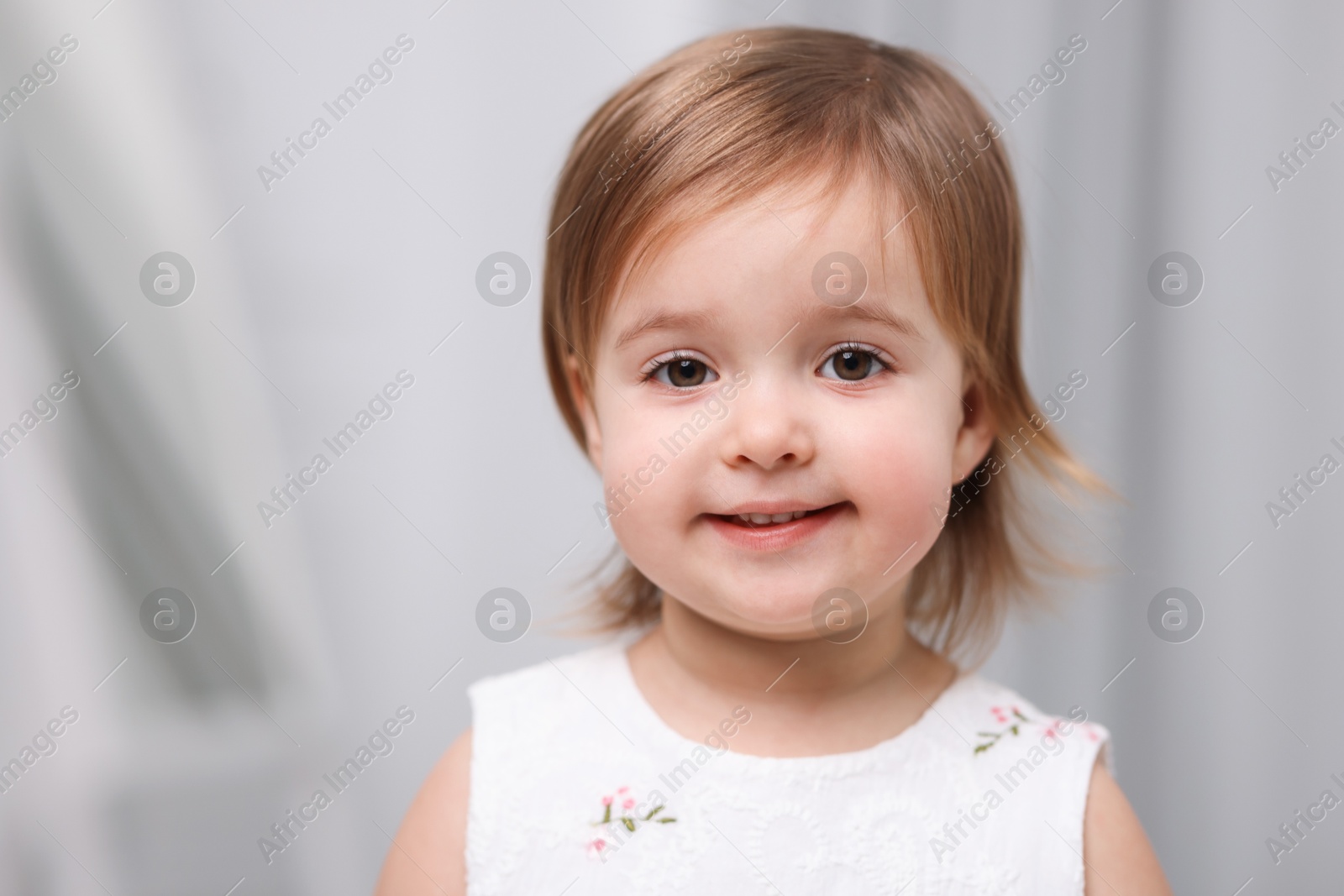 Photo of Cute little baby girl on light grey background