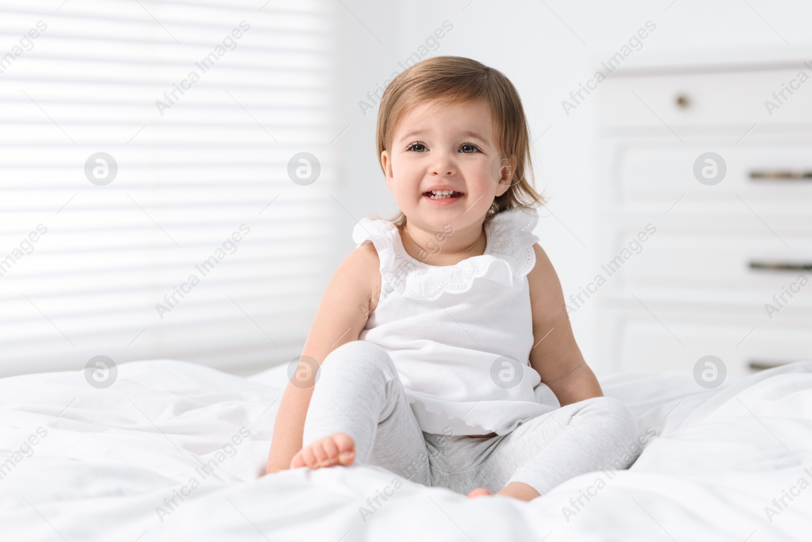 Photo of Cute little baby girl on bed at home