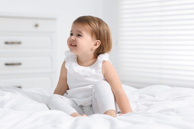 Photo of Cute little baby girl on bed at home