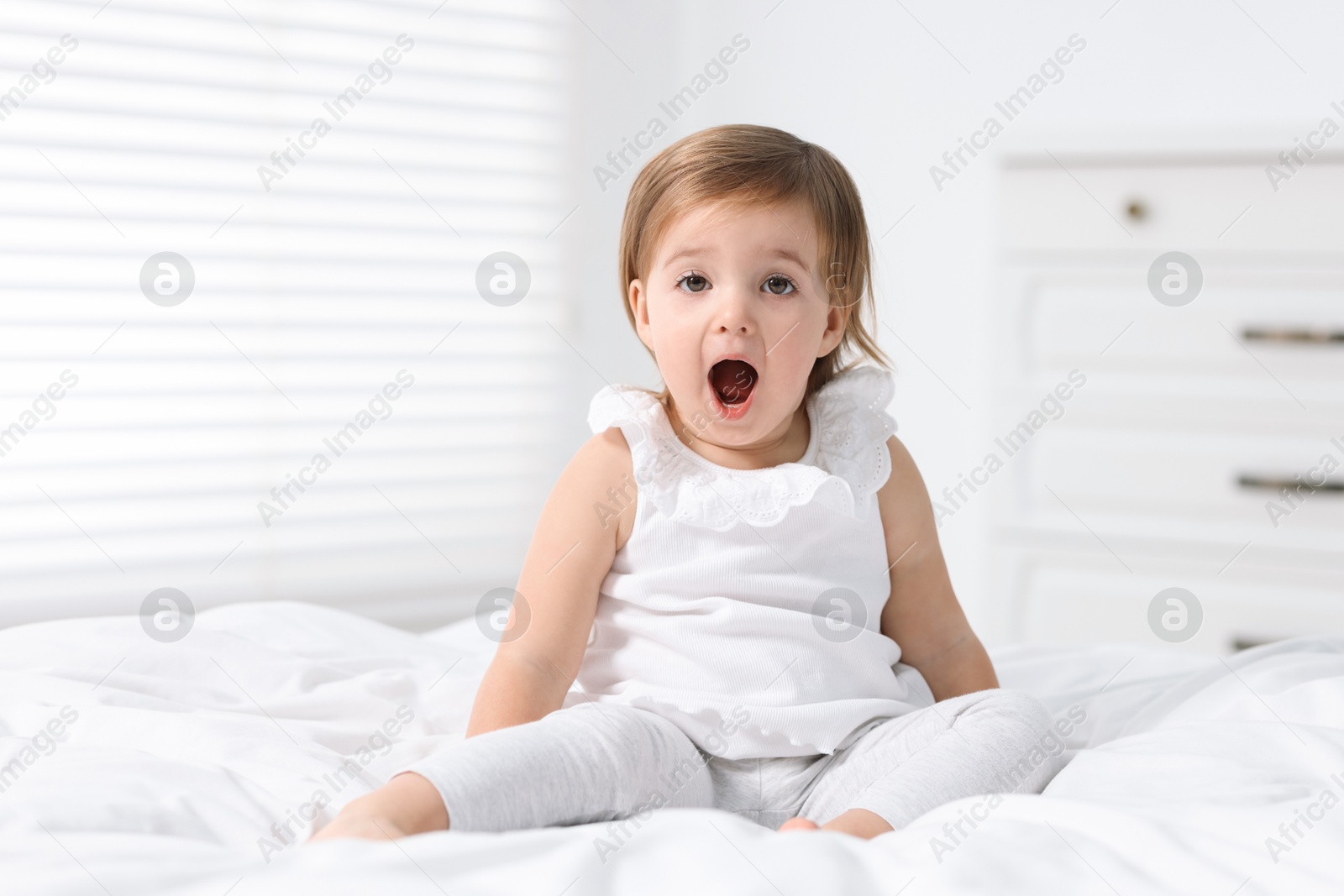 Photo of Cute little baby girl on bed at home