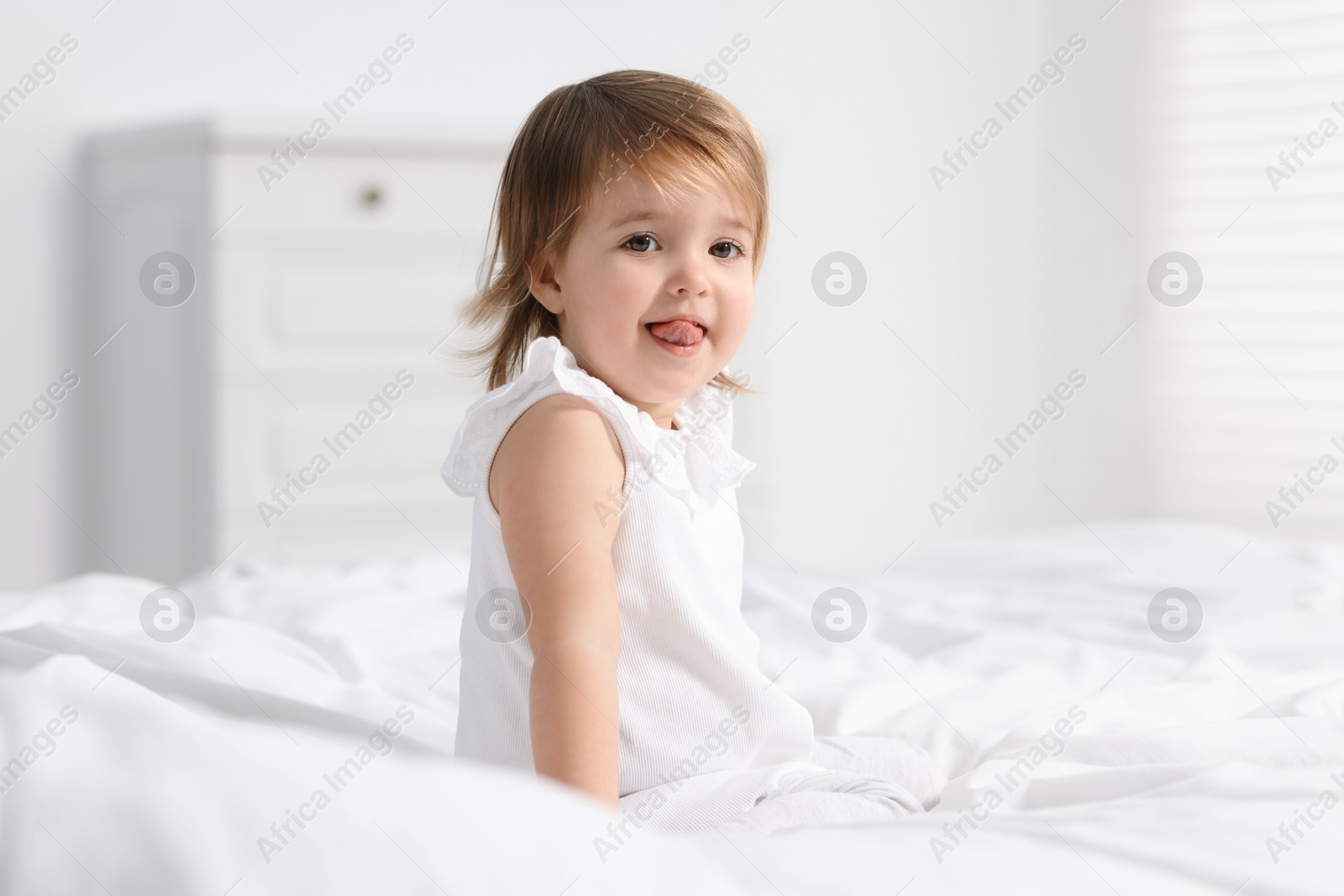 Photo of Cute little baby girl on bed at home