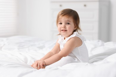 Photo of Cute little baby girl on bed at home