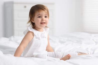 Photo of Cute little baby girl on bed at home