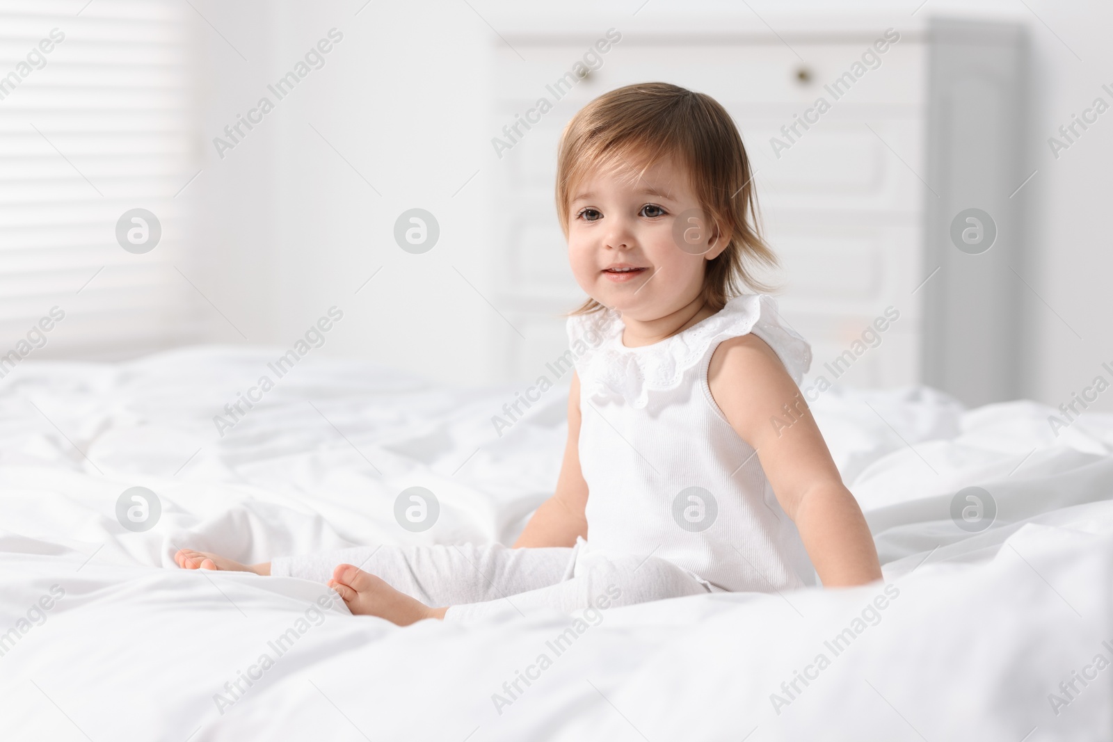 Photo of Cute little baby girl on bed at home