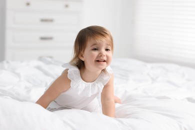 Photo of Cute little baby girl on bed at home