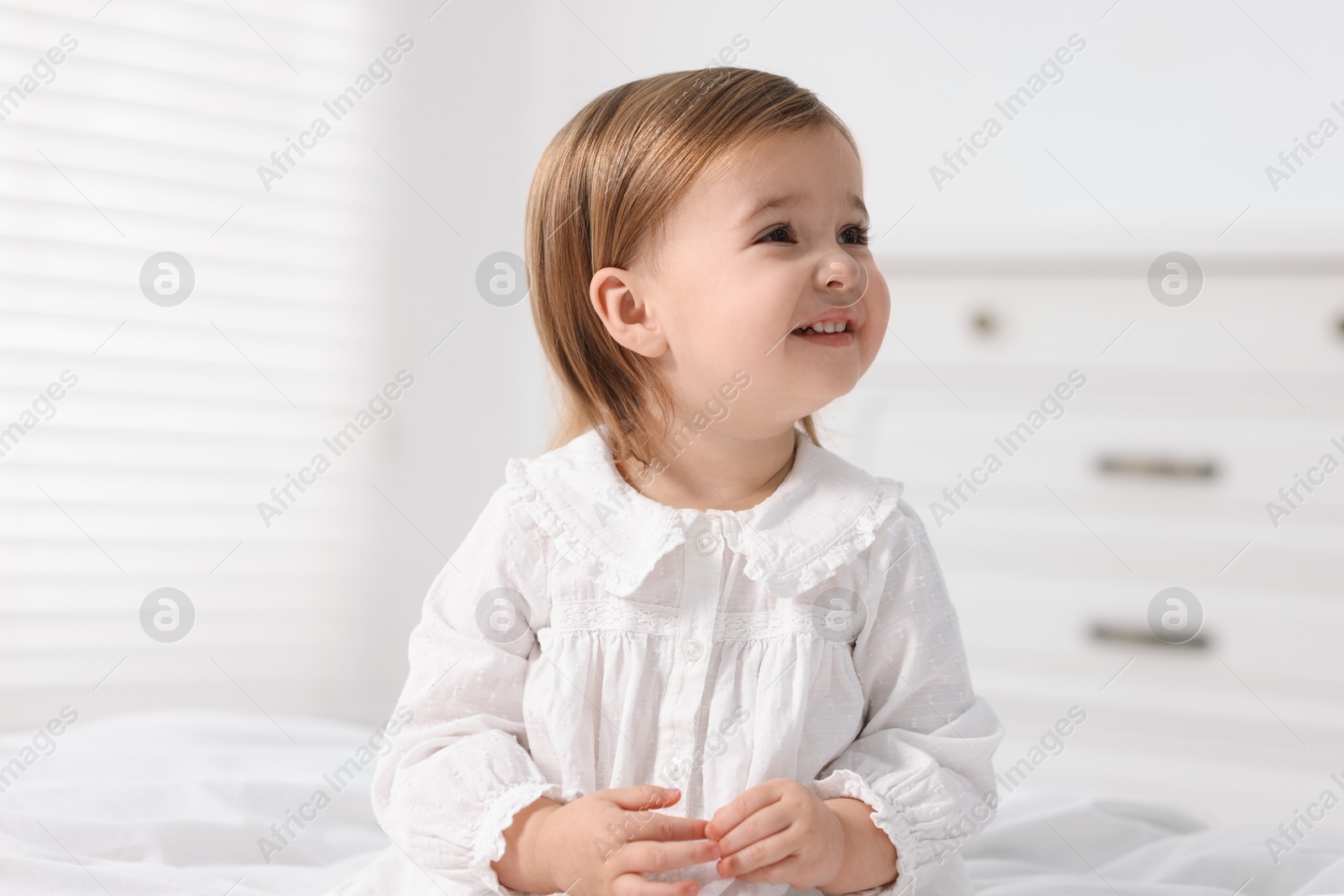 Photo of Cute little baby girl on bed at home