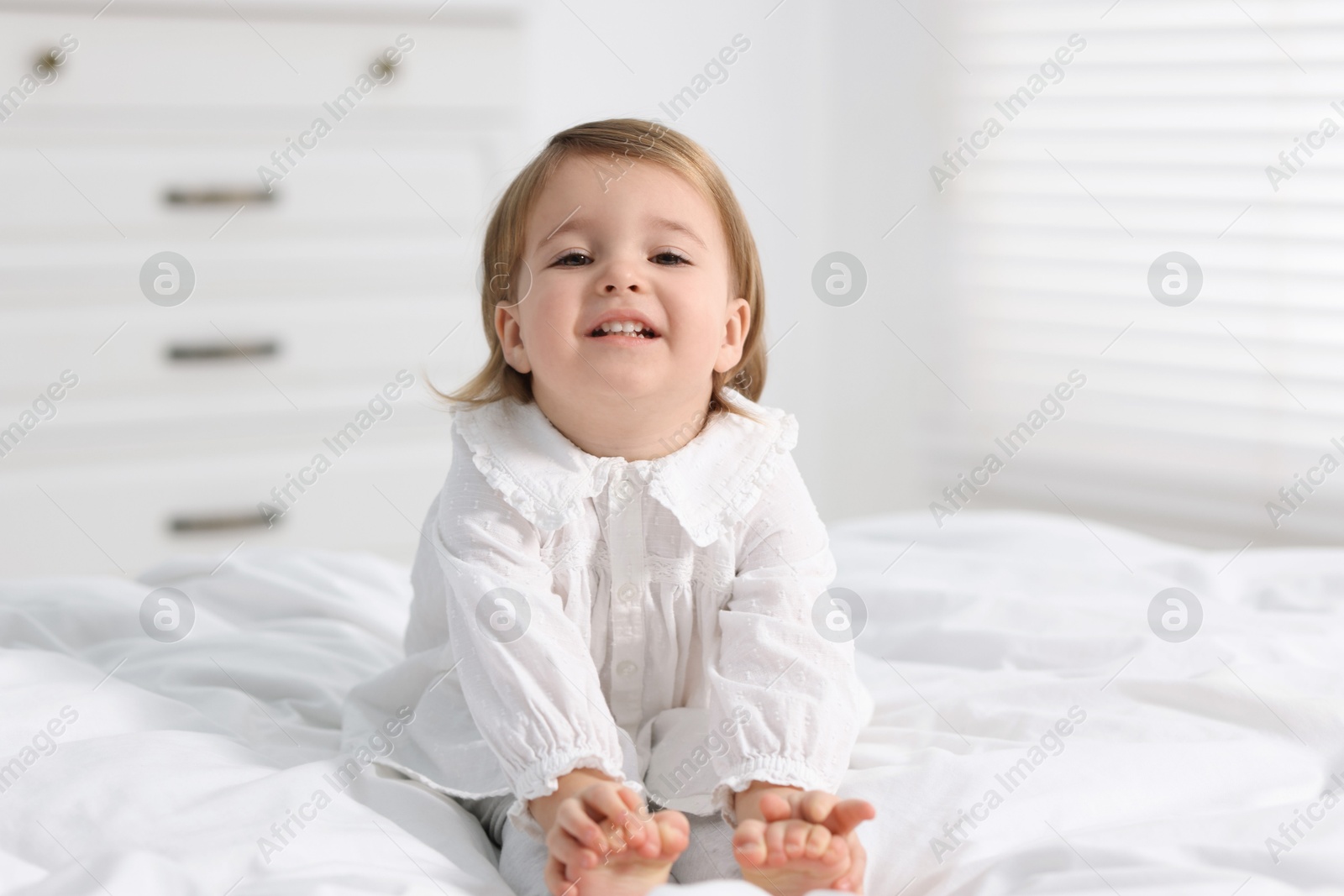 Photo of Cute little baby girl on bed at home