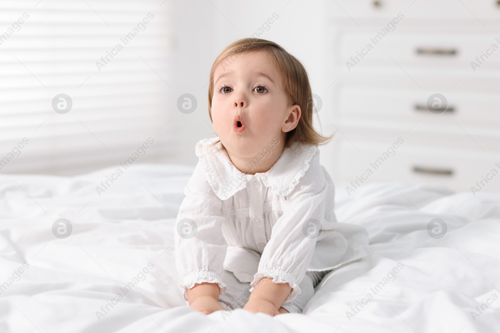 Photo of Cute little baby girl on bed at home