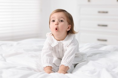 Photo of Cute little baby girl on bed at home