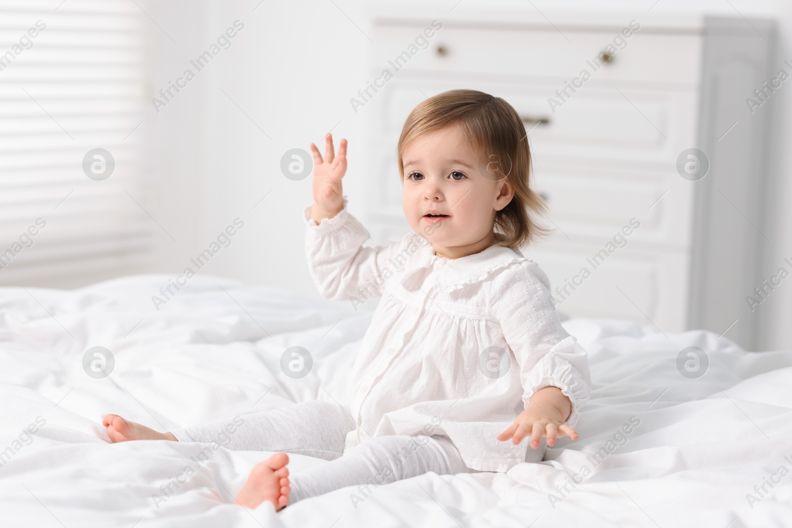 Photo of Cute little baby girl on bed at home