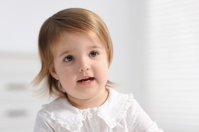 Photo of Portrait of cute little baby girl on light background