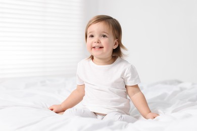 Photo of Cute little baby girl on bed at home