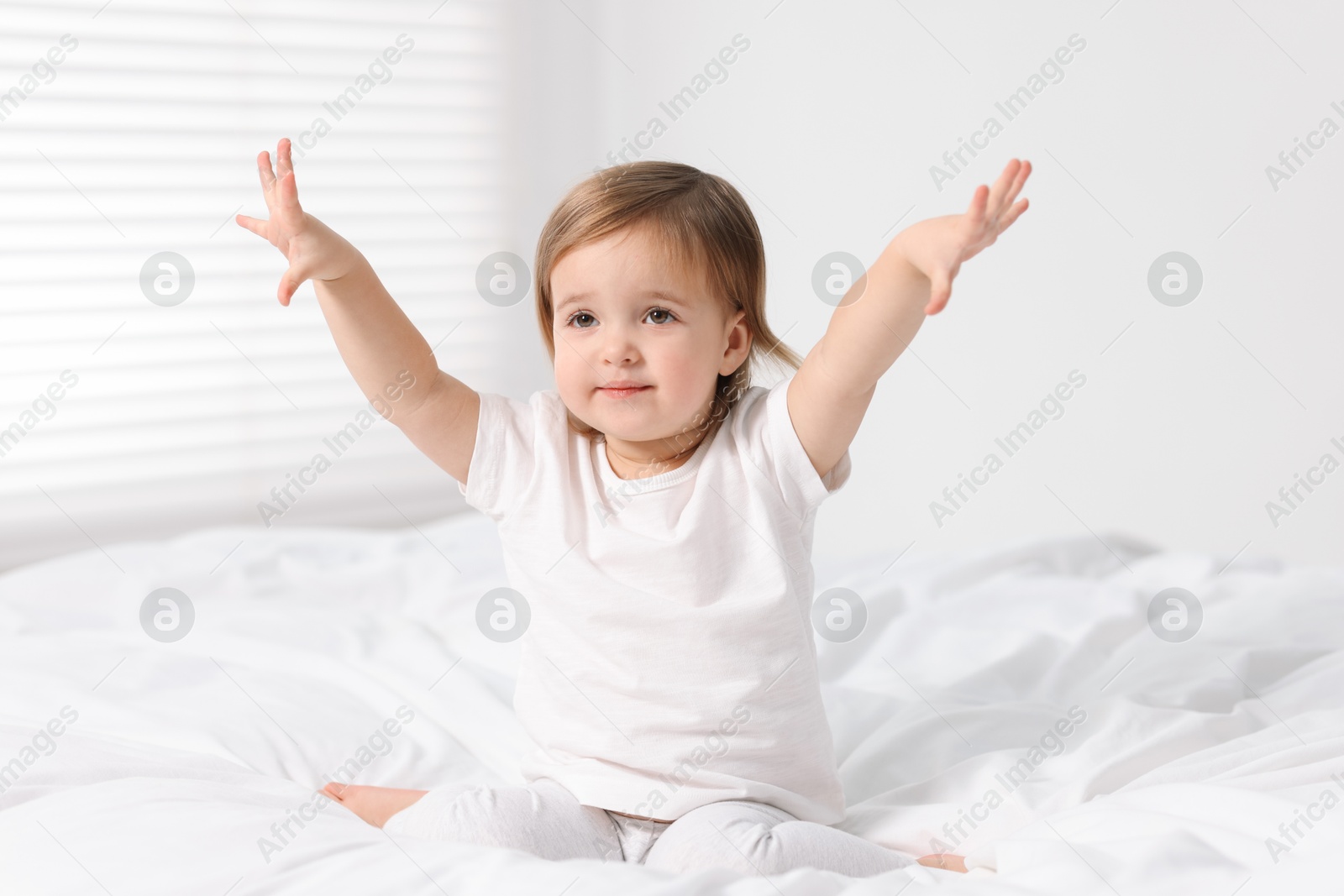 Photo of Cute little baby girl on bed at home