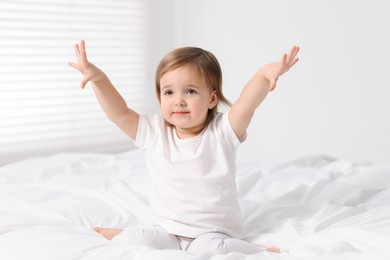 Photo of Cute little baby girl on bed at home