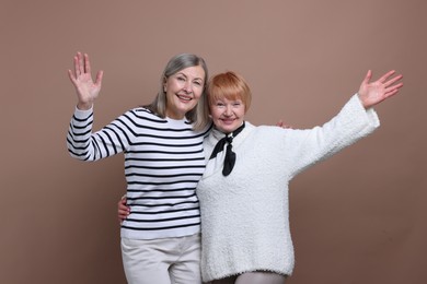 Photo of Friendship. Portrait of senior women on dark beige background