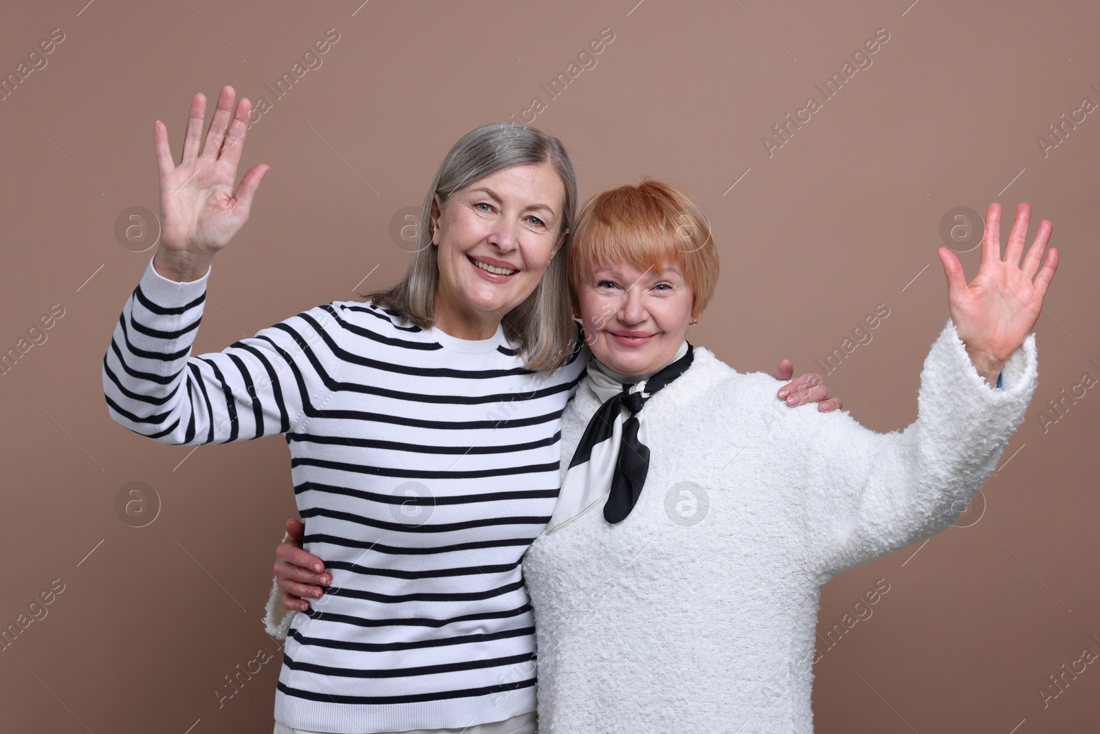 Photo of Friendship. Portrait of senior women on dark beige background