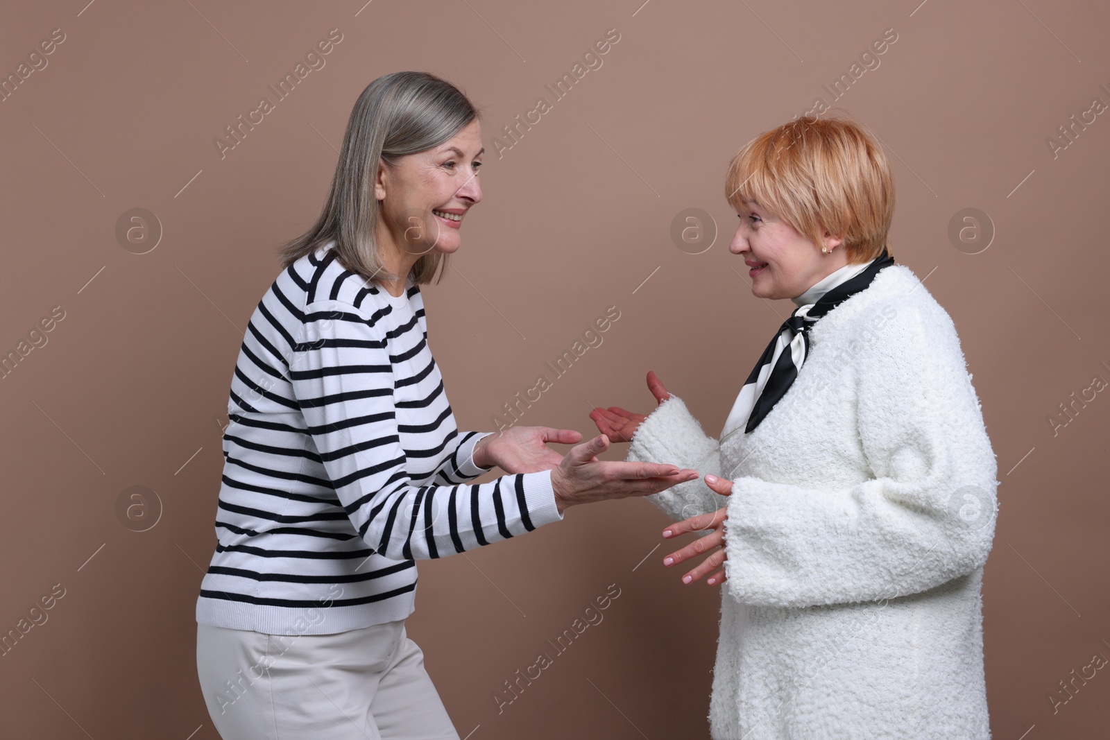 Photo of Friendship. Portrait of senior women on dark beige background