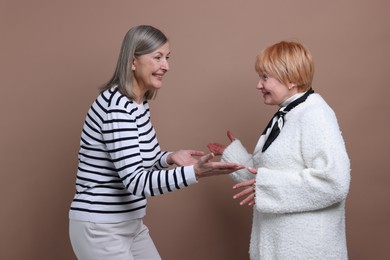 Photo of Friendship. Portrait of senior women on dark beige background