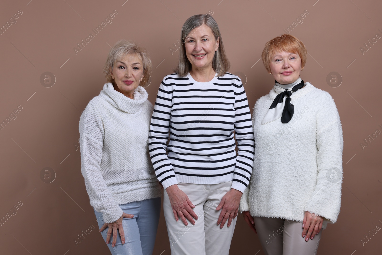 Photo of Friendship. Portrait of senior women on dark beige background