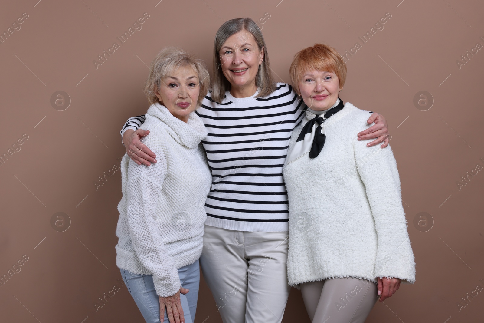 Photo of Friendship. Portrait of senior women on dark beige background