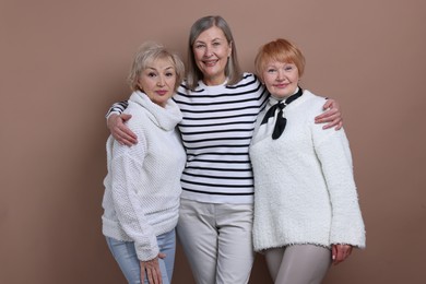 Photo of Friendship. Portrait of senior women on dark beige background