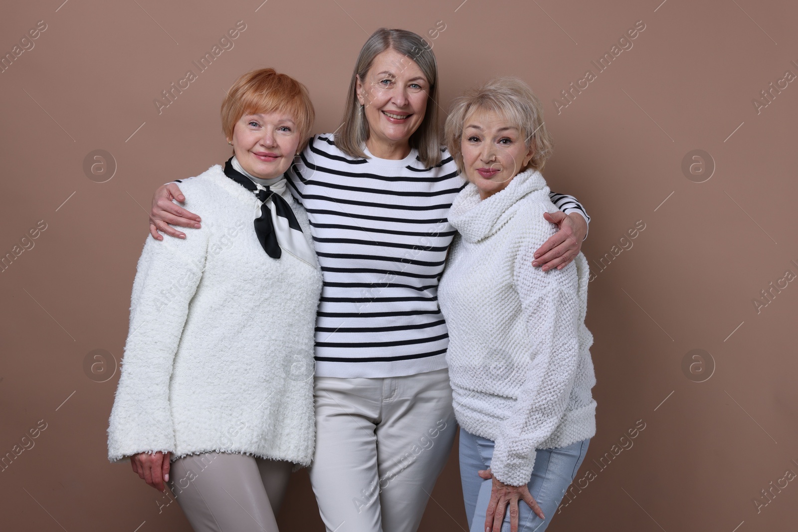 Photo of Friendship. Portrait of senior women on dark beige background