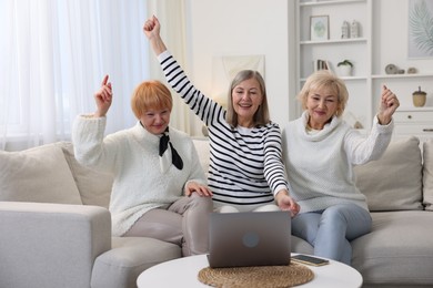 Photo of Friendship. Senior women watching something on laptop at home