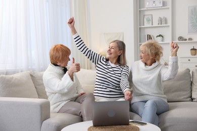 Friendship. Senior women watching something on laptop at home