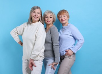 Friendship. Portrait of senior women on light blue background