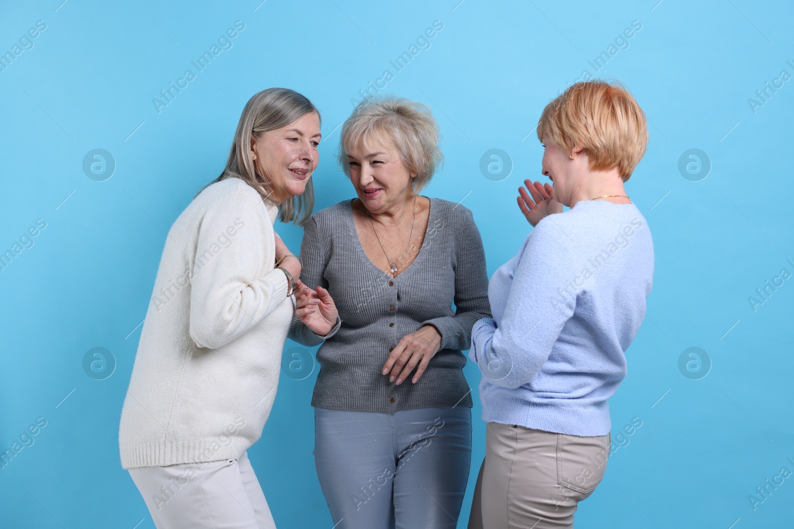 Photo of Friendship. Portrait of senior women on light blue background