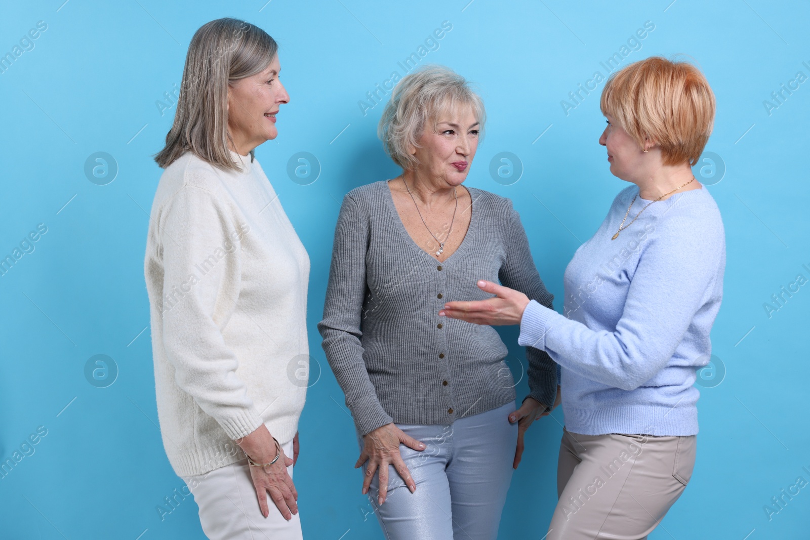 Photo of Friendship. Portrait of senior women on light blue background