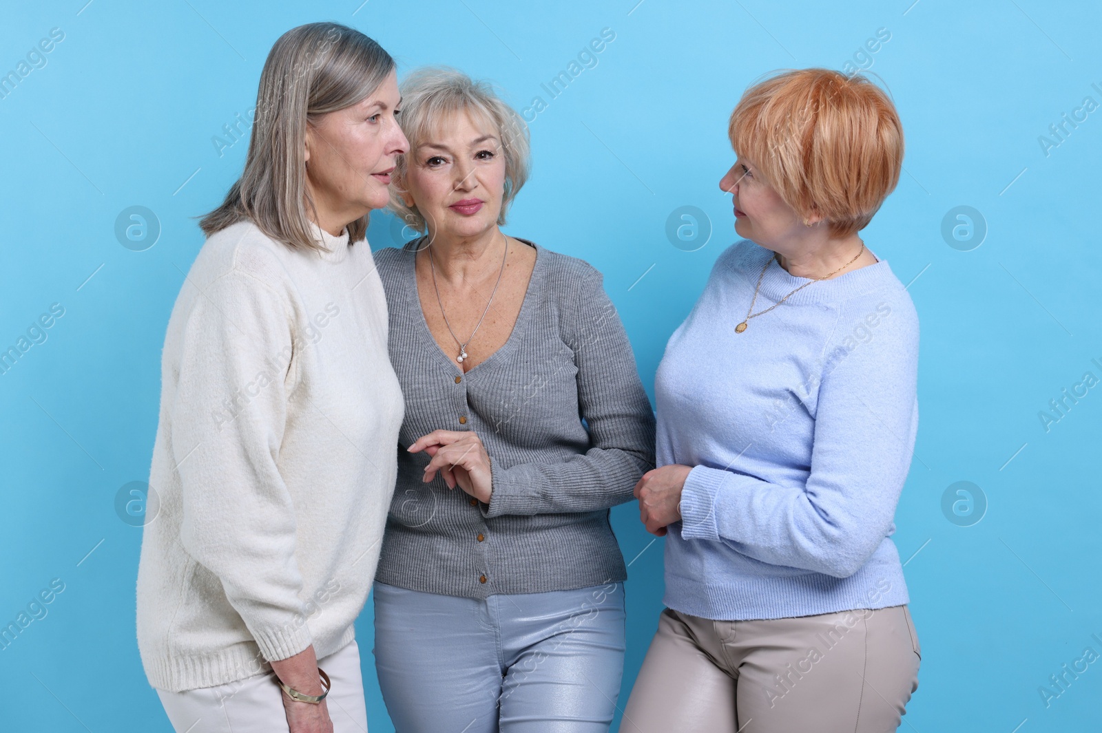 Photo of Friendship. Portrait of senior women on light blue background