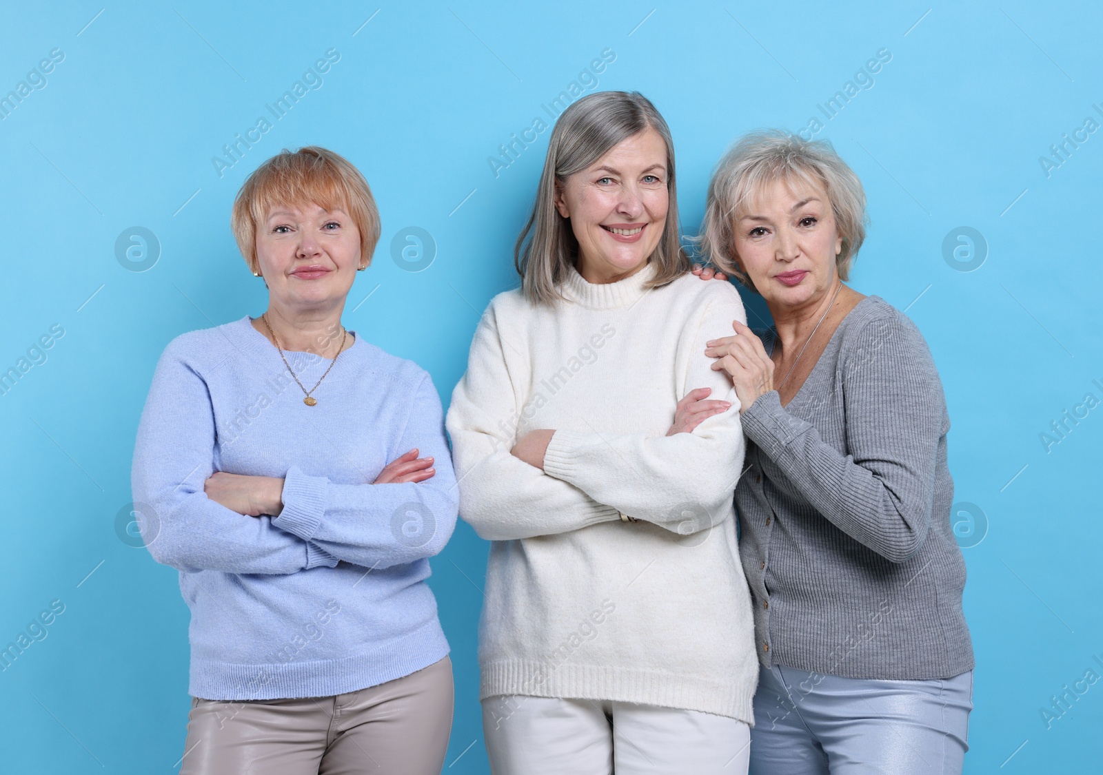 Photo of Friendship. Portrait of senior women on light blue background