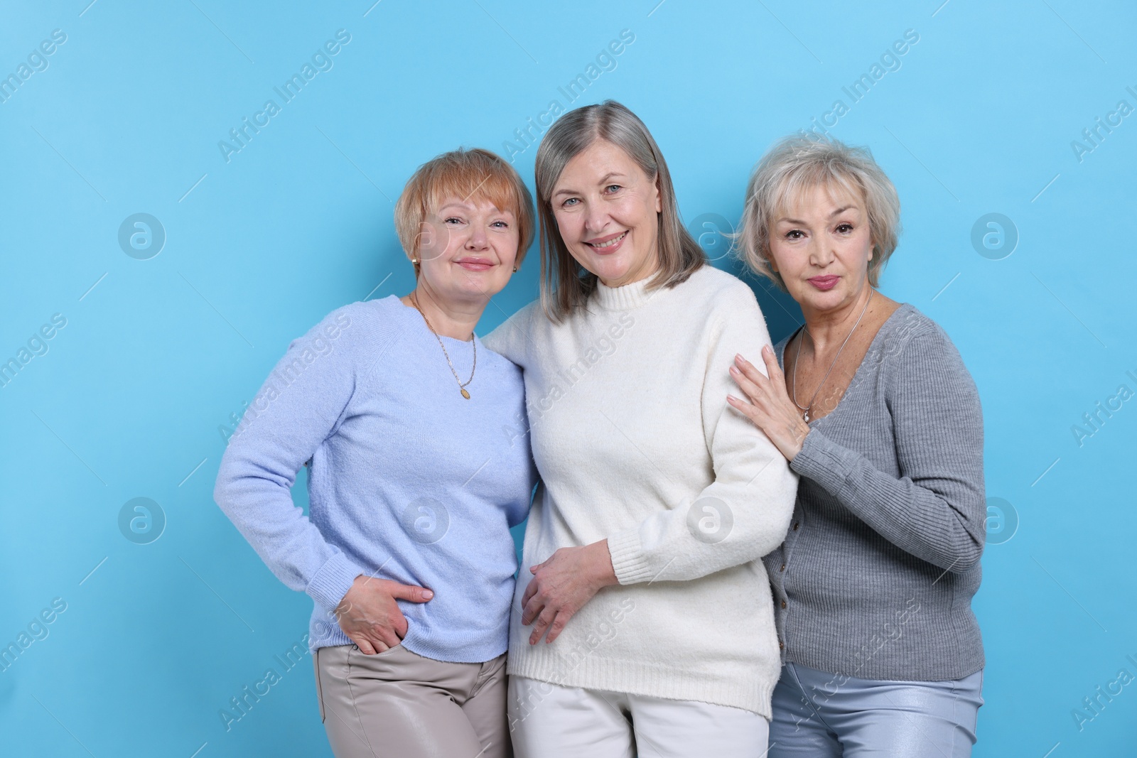 Photo of Friendship. Portrait of senior women on light blue background