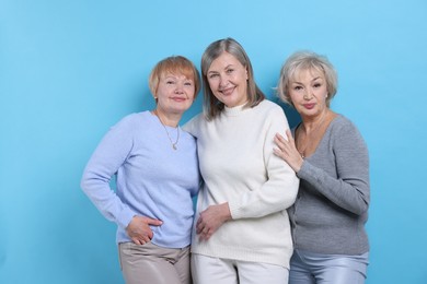 Photo of Friendship. Portrait of senior women on light blue background